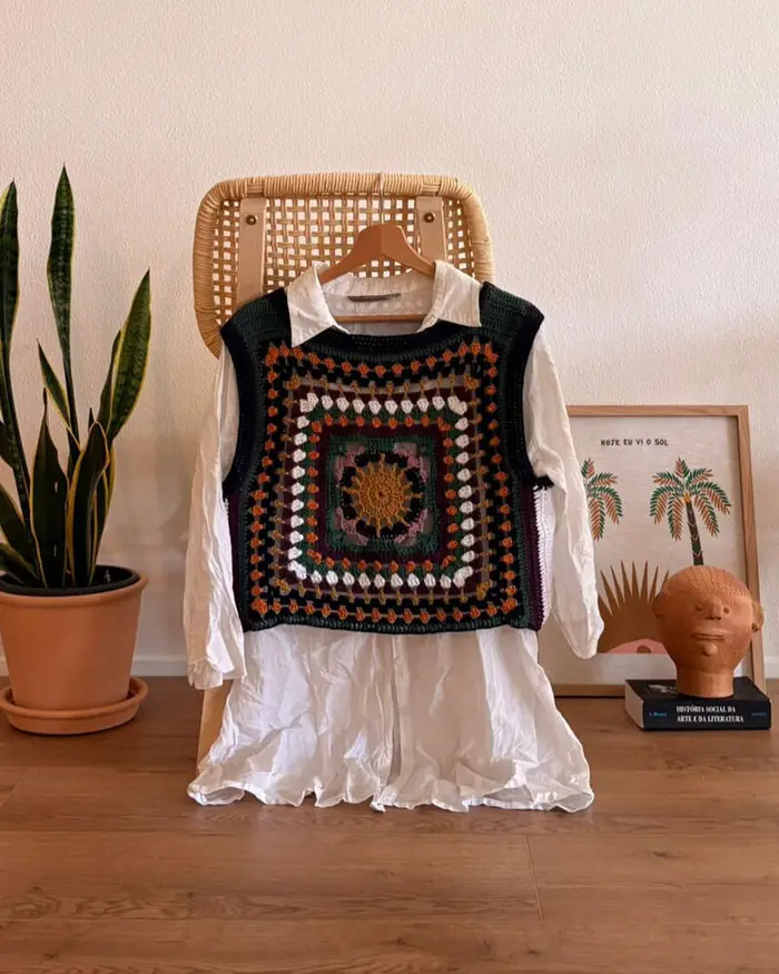 Granny square vest displayed on a rattan chair