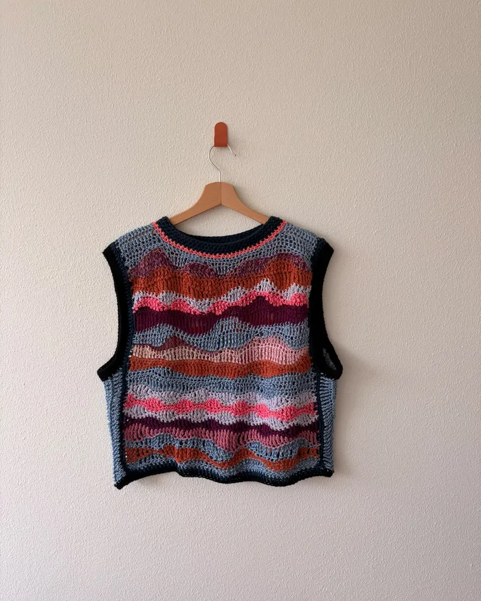 The Baía dos Golfinhos vest hanging on a wall, one side