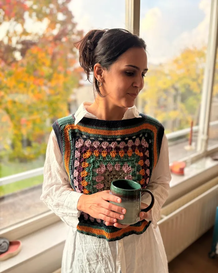 The same Melina vest at the window, looking down