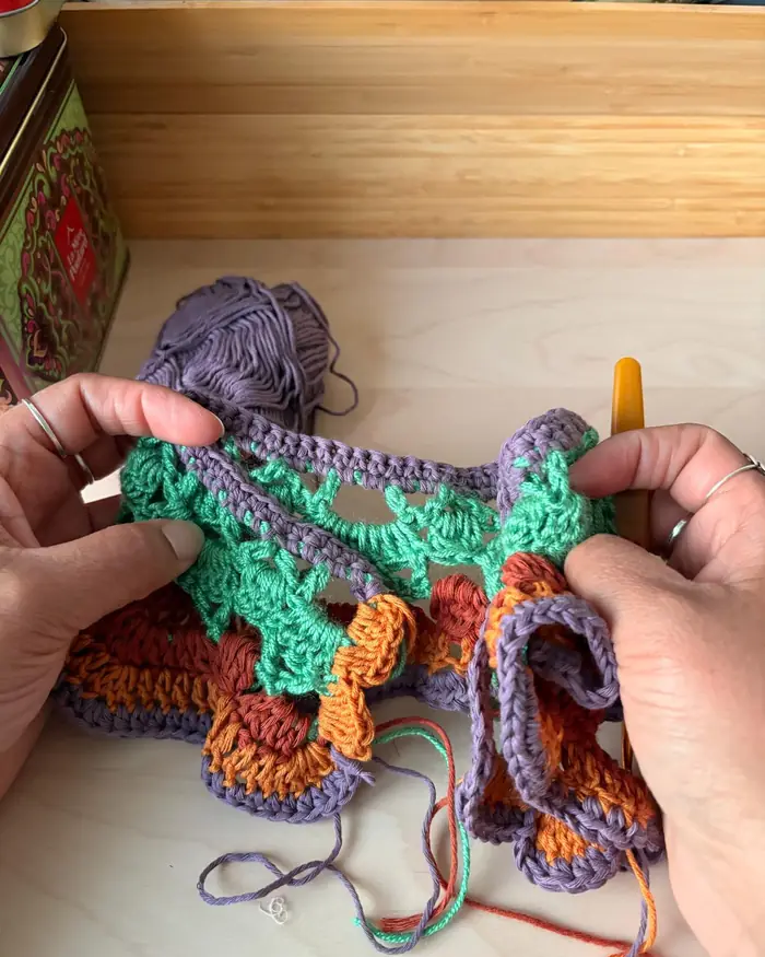 Hands crocheting a piece in progress