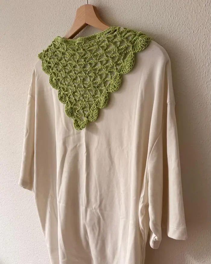 Green crochet collar laid on a cream shirt